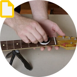 person cleaning guitar fretboard